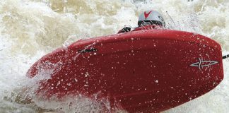 Paddler catches some air in a Pyranha Kingpin Icon whitewater kayak