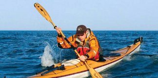 Person paddling an orange sea kayak