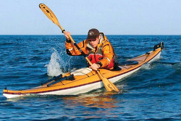 Person paddling an orange sea kayak