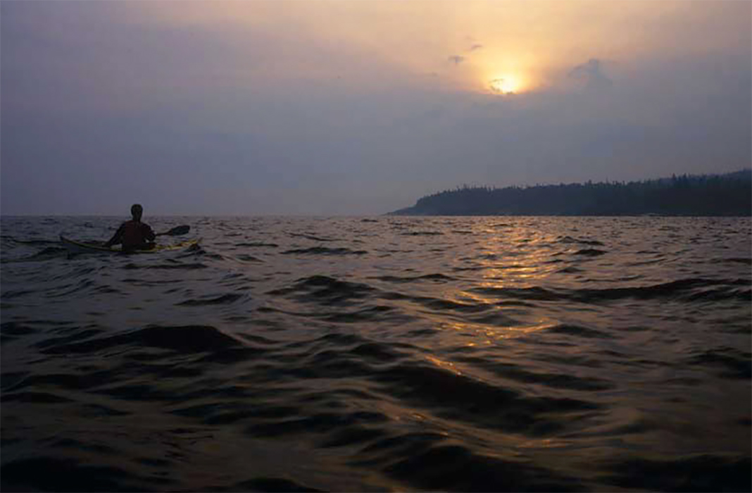 Person on kayak on Lake Superior as darkness is falling