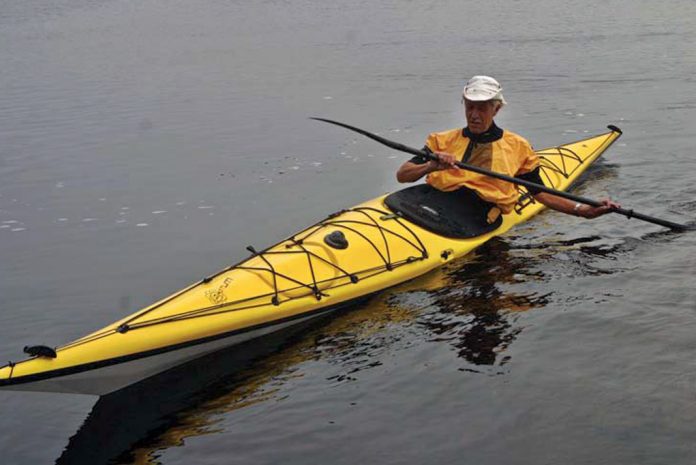 Man paddling yellow sea kayak