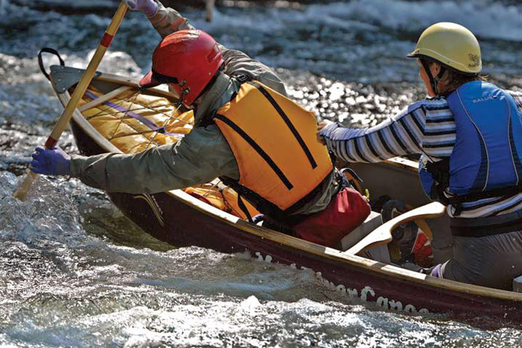 Two people paddling whitewater canoe.