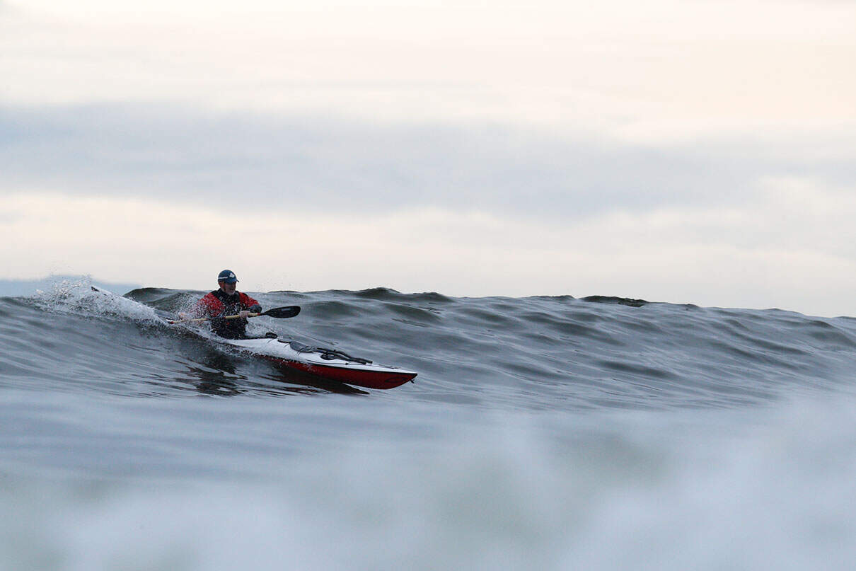 a man kayak surfing on a wave