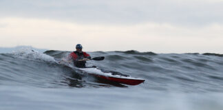 a man kayak surfing on a wave
