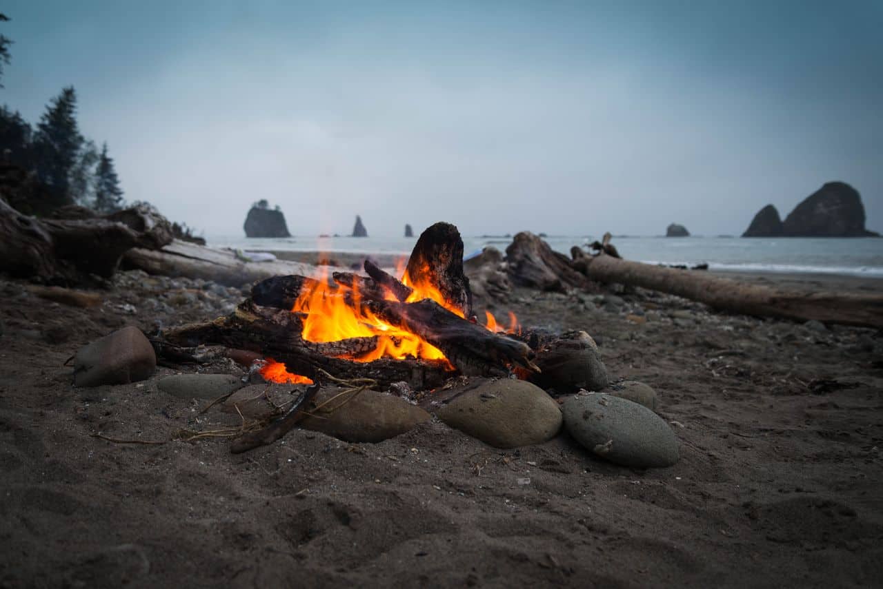 Warm campfire on a rocky beach along the Olympic Coast, perfect for a relaxing evening.