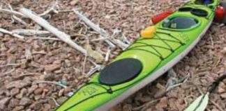 an impex currituck kayak sitting on pebbles