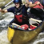Boat Review: Mad River Caption Canoe Two people paddle through whitewater in a Mad River Caption canoe