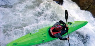 Person paddles a Dagger Green Boat kayak through river rapids