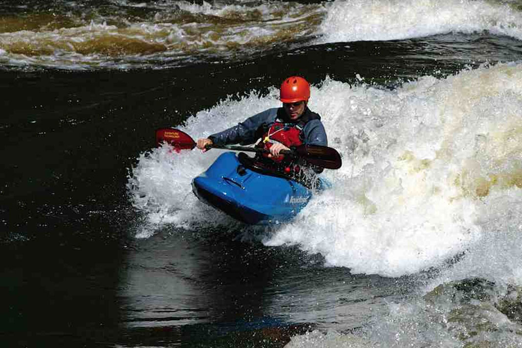Man surfs a wave in the Liquidlogic Biscuit whitewater kayak