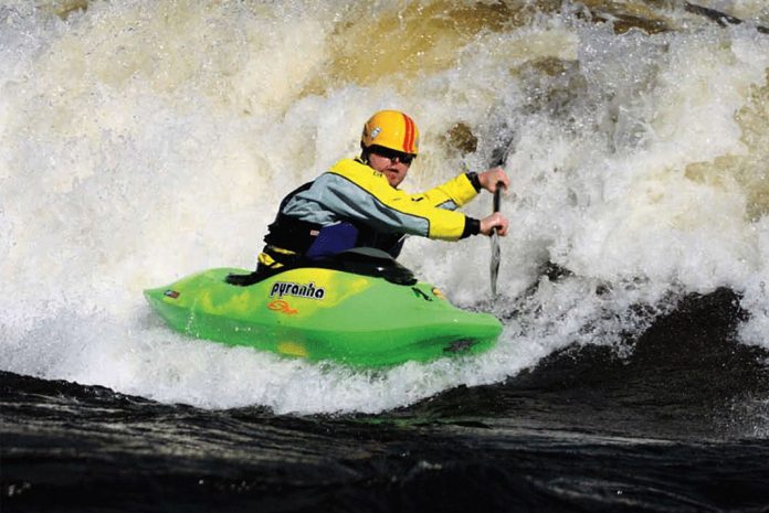 Man paddles a Pyranha Molan freestyle kayak through whitewater