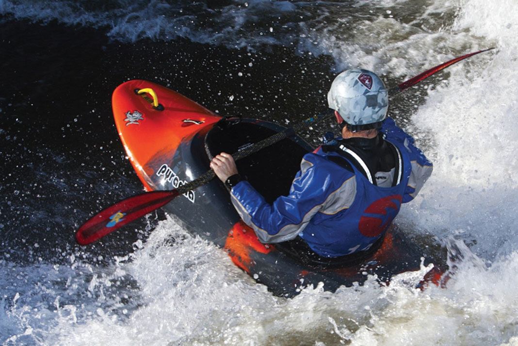 Man paddles through rapids in a Pyranha Varun whitewater kayak