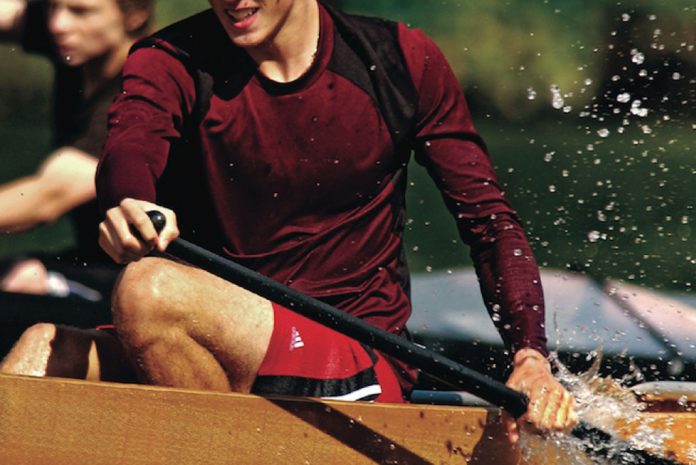 Young men paddle in a canoe marathon race