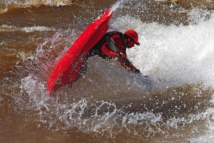 Man does a freestyle trick in a WaveSport Project X kayak