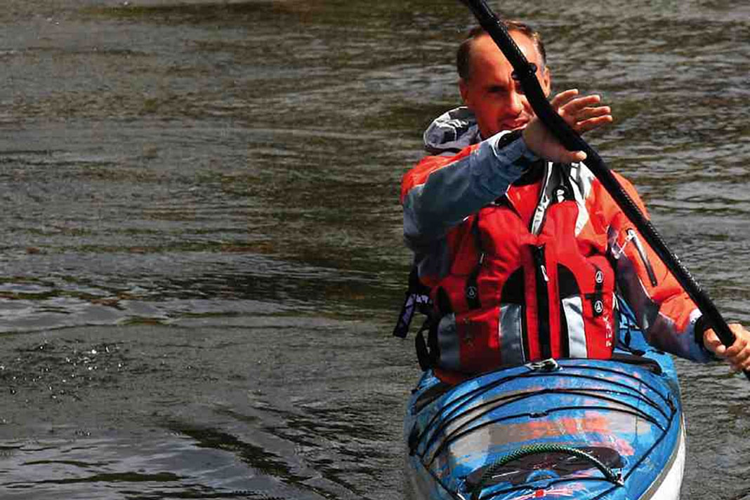 Man in a kayak prepares to demonstrate the kayak forward stroke