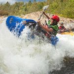 Kayak Surf School: Learn The Basics Of Surf Kayaking Person in blue kayak riding a wave