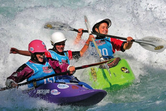 freestyle kayak race competitors paddle in whitewater