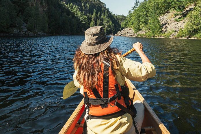 Photo of woman in bow of a canoe paddling