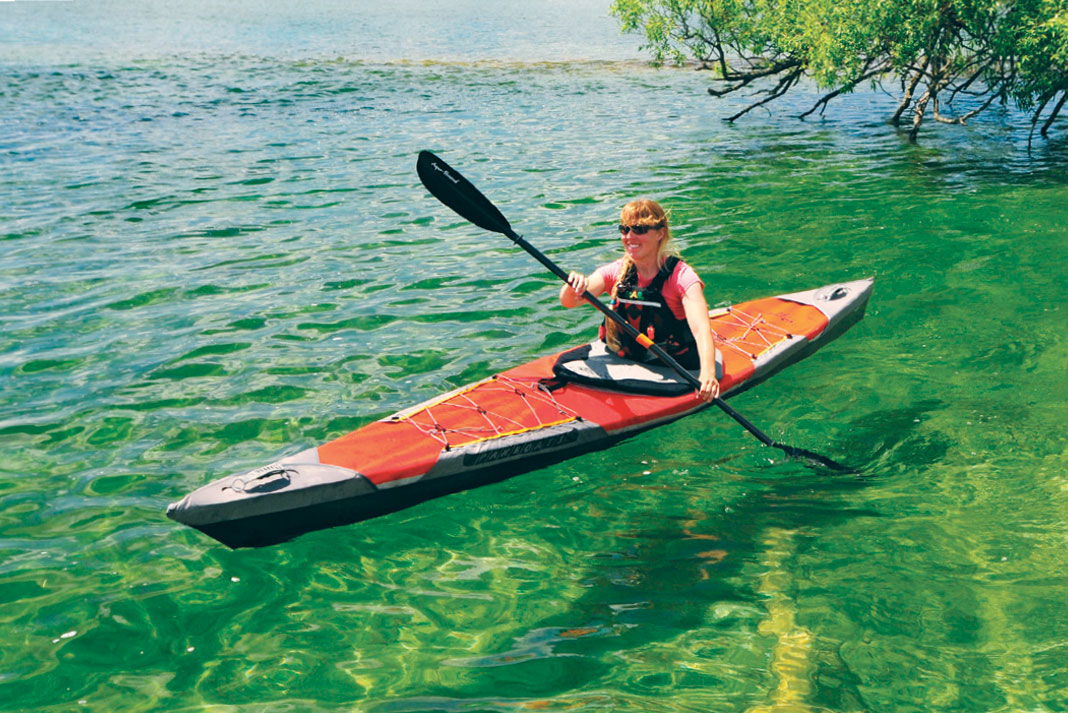 Woman paddling red folding touring kayak