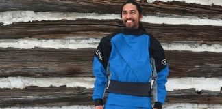 Man standing outside wearing blue and black drysuit