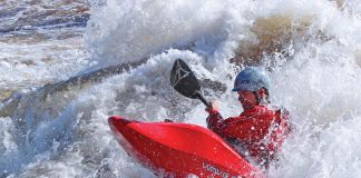 Man using red whitewater kayak