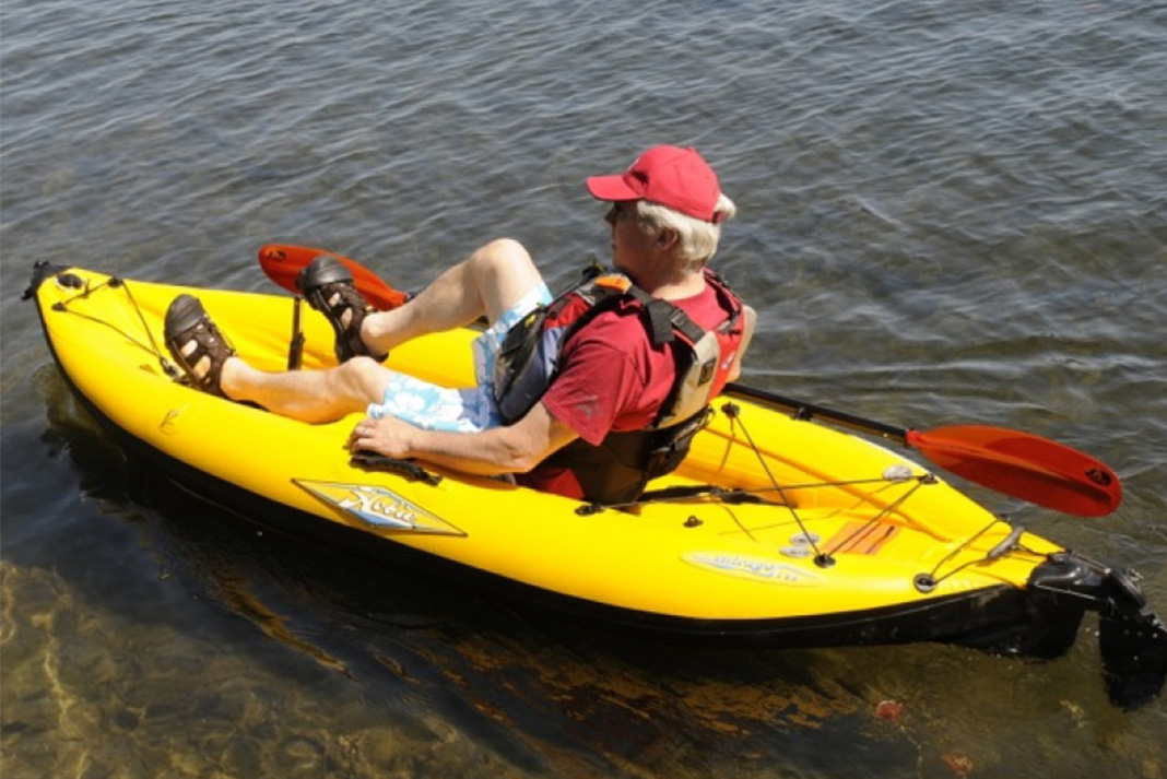 Man sits on yellow inflatable pedal-drive kayak