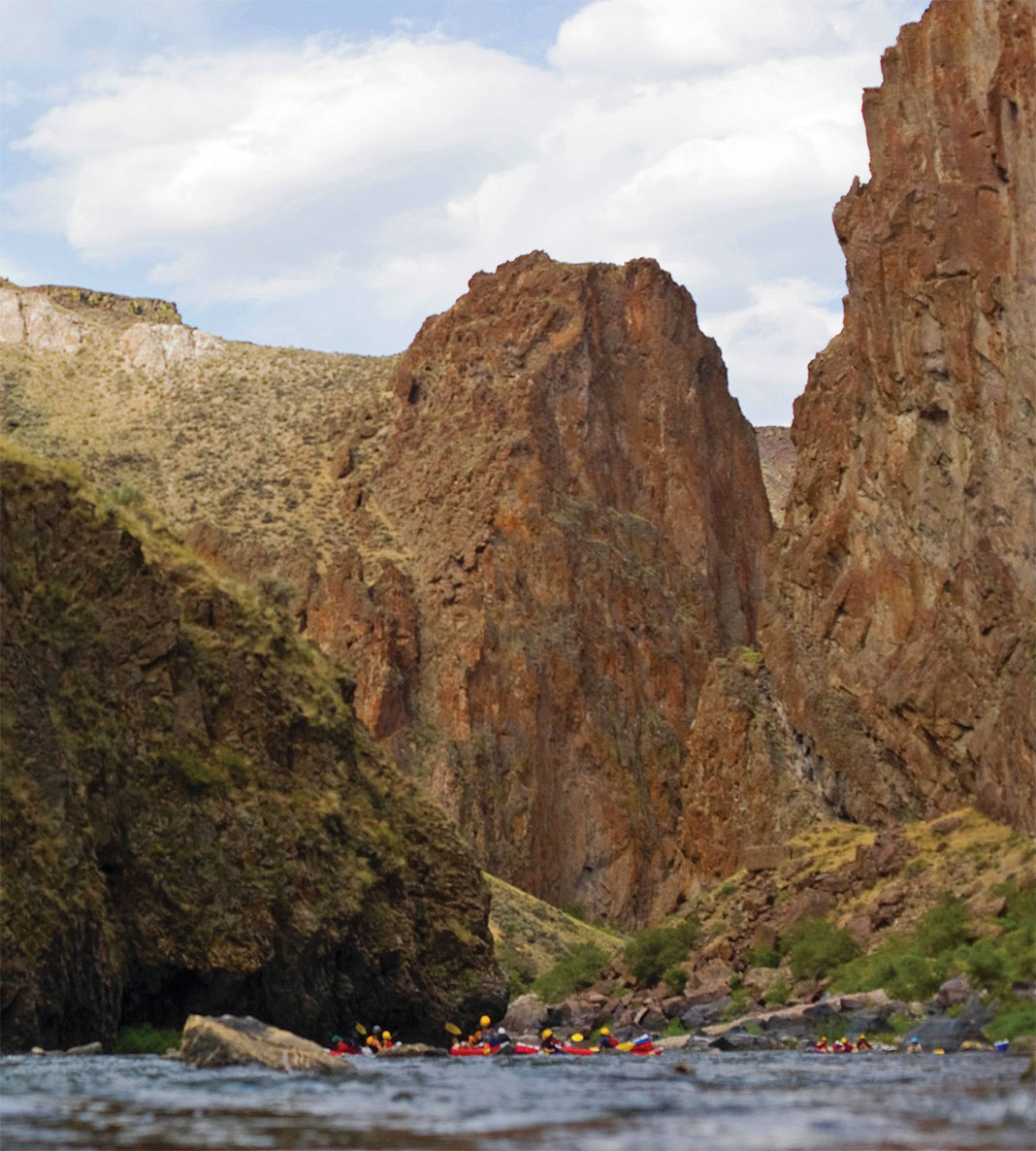 Kayakers paddling at base of canyon walls