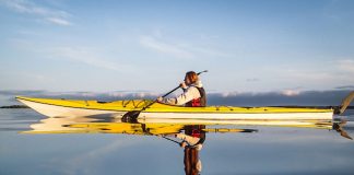 Woman paddling a sea kayak on calm waters