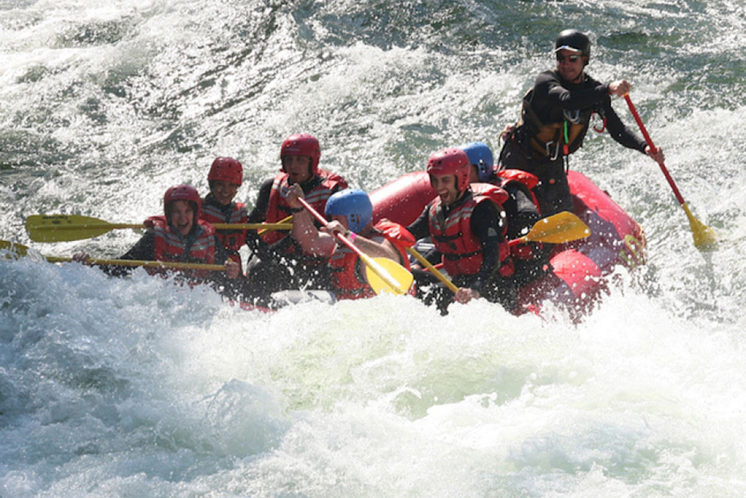 A whitewater river rafting guide on the job, taking a group of paddlers downstream