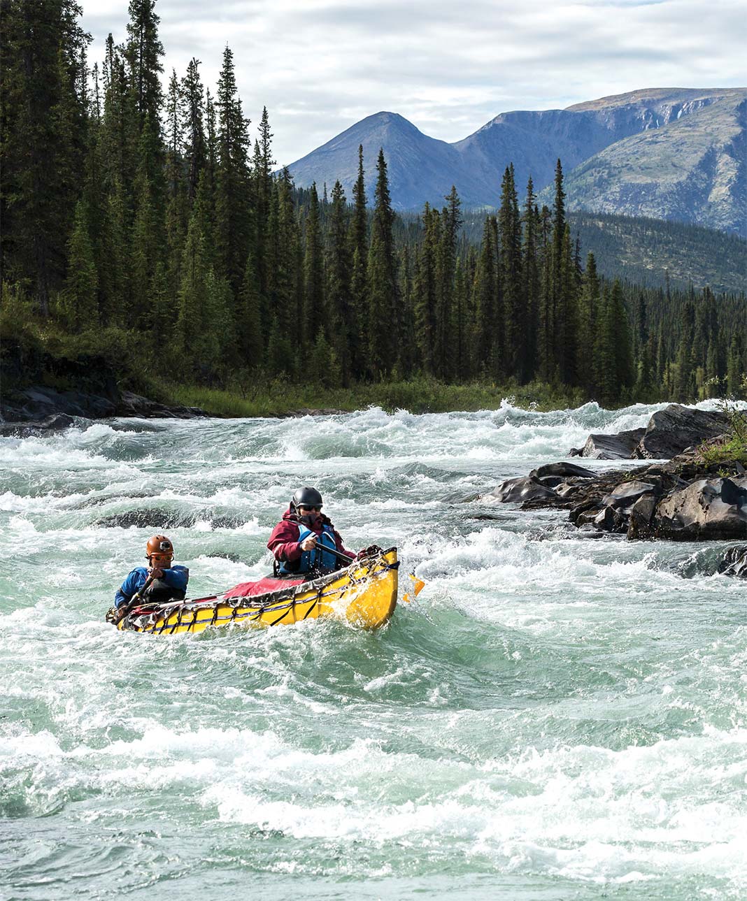 Tandem canoe going through whitewater