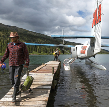 Floatplane beside dock with person walking toward camera
