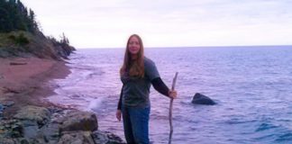 Traci Lynn Martin, planning for longest kayak trip, stands on a rocky beach