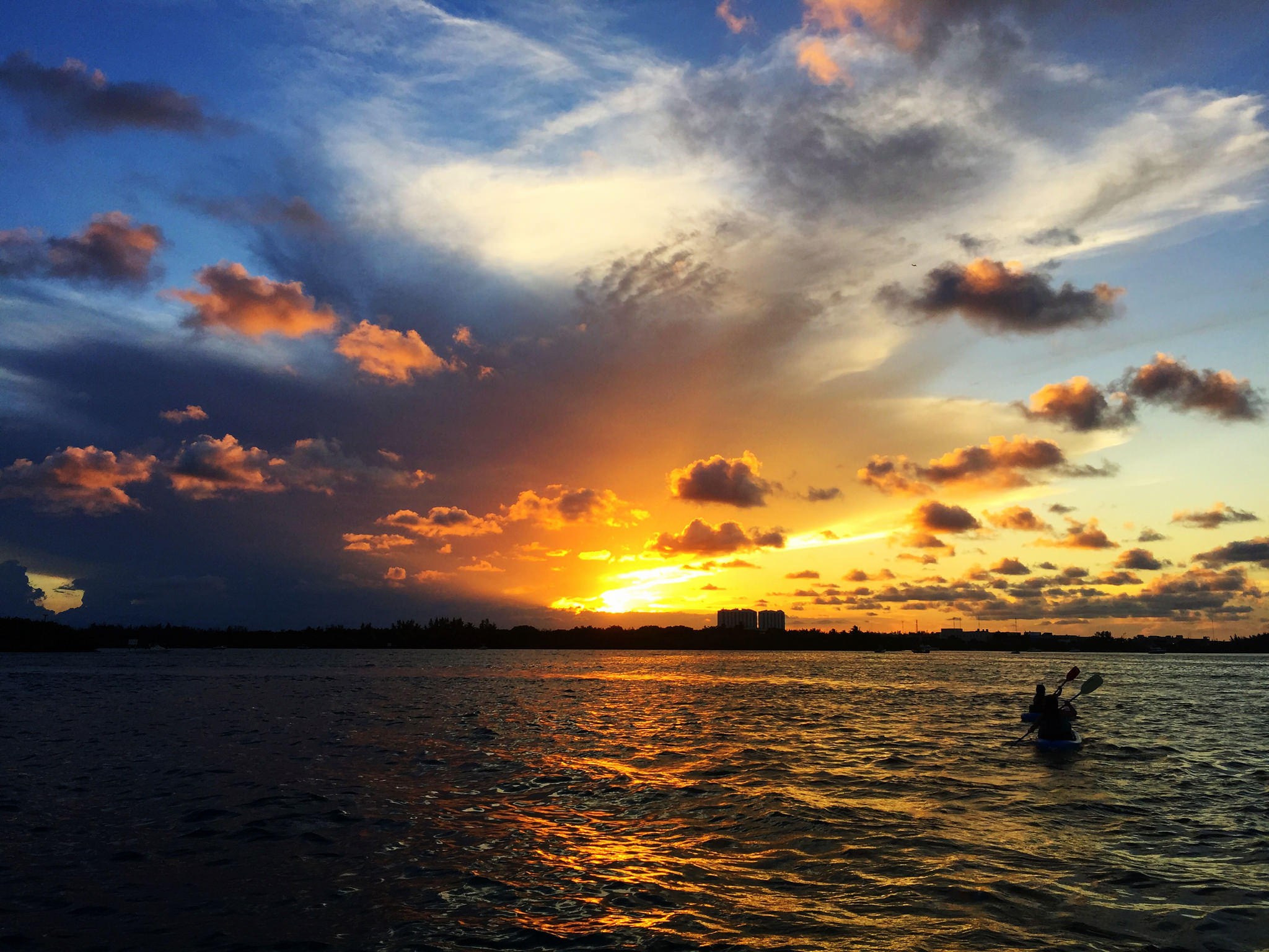 A kayaker paddles into the sunset.