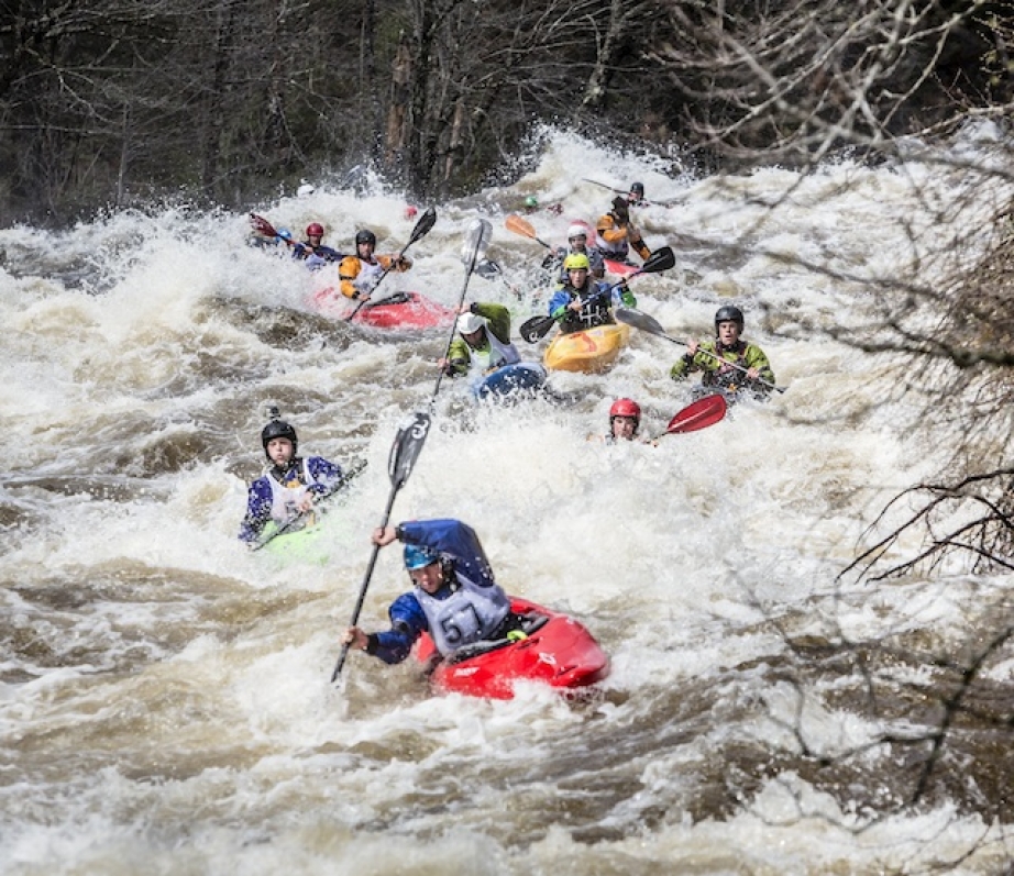 A group of whitewater kayak racers paddle through whitewater in Quebec's Neilson Race