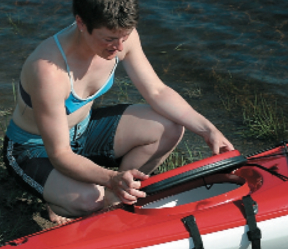 woman opens the hatch of a Perception Sonoma 13.5 kayak in Airalite