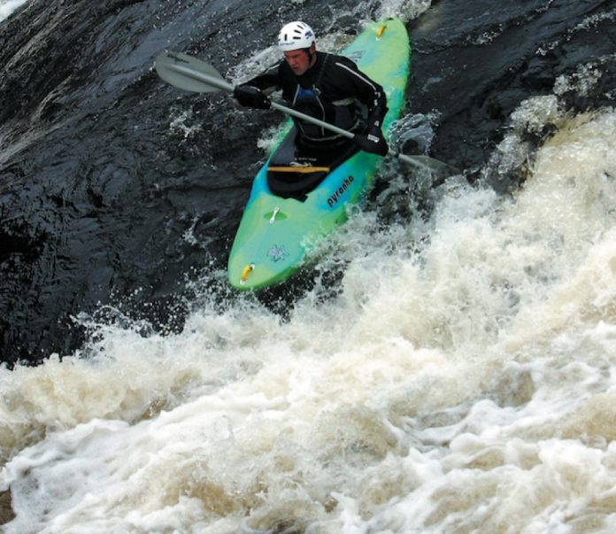 kayaker paddling down a rapid in Pyranha's H:3 river running kayak