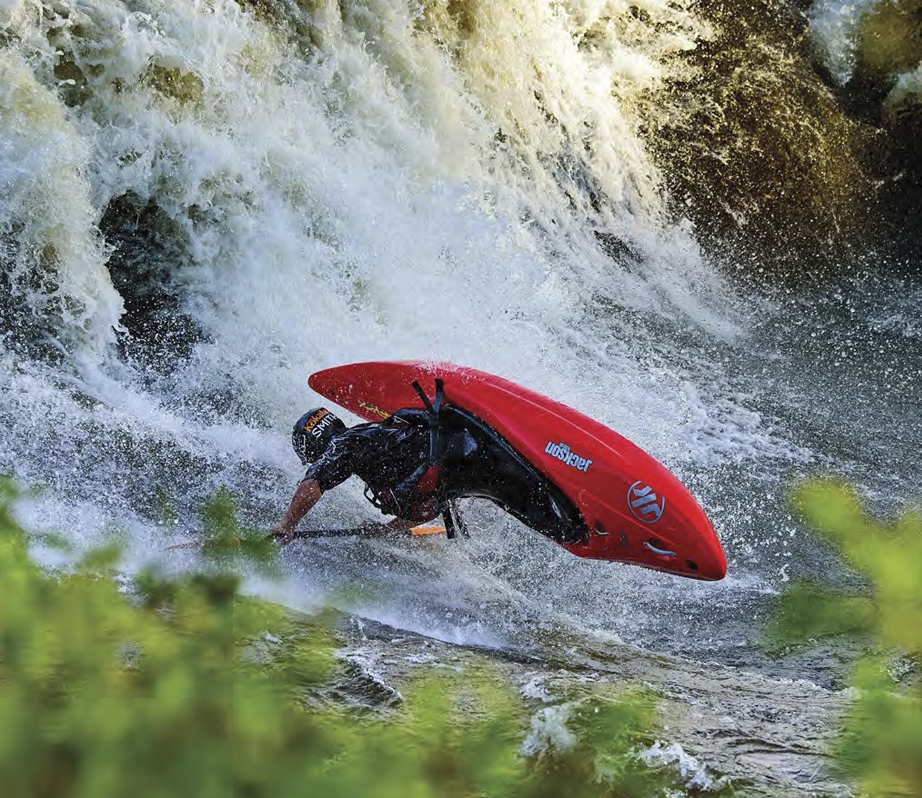 A person flipping in a whitewater kayak.