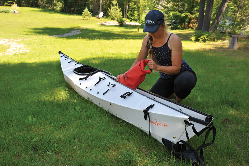 A woman finishes assembling the Oru Kayak.