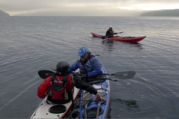 Leon Somme and Shawna Franklin repair a kayak on the ocean in a rescue situation