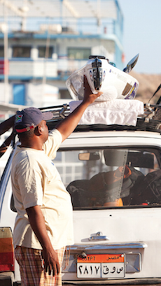 Man adjusting kayak on car in Egypt