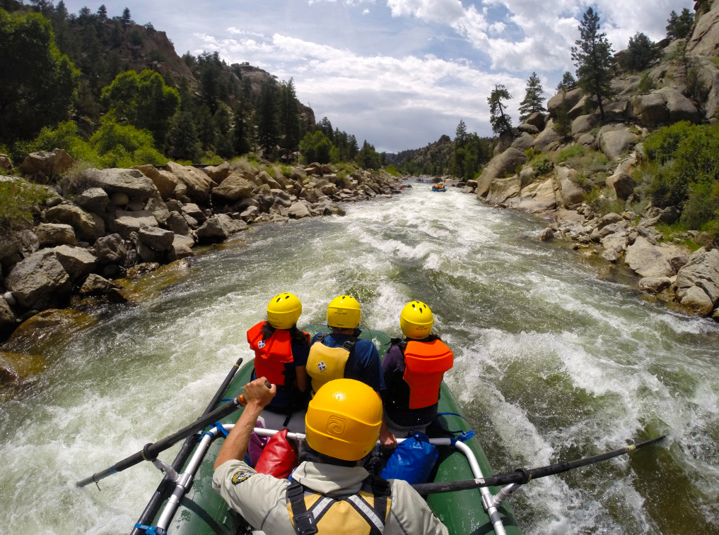 A boat of rafters float down a white water river in Colorado. 
