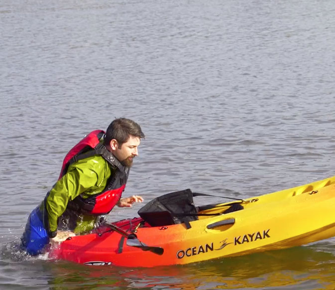 Paul Kuthe pulls his body onto the back of his kayak.