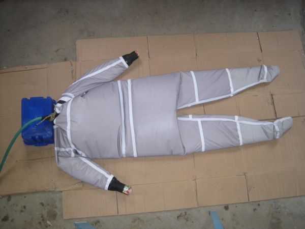A drysuit lies on the floor filled with water during a leak test