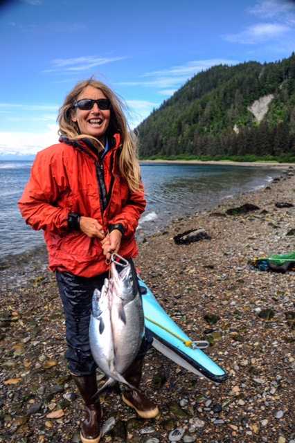 Nancy Pfieffer holds her salmon catch during a summer kayaking and subsistence trip in Southeast Alaska