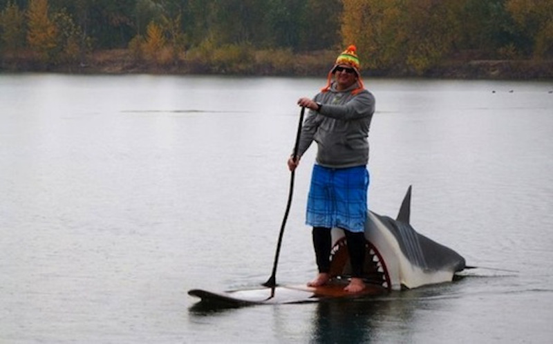 A SUP paddler in a shark halloween costume. 