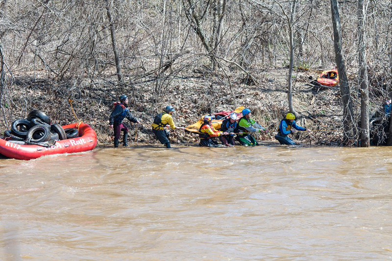 Paddlers pull tires out of the Nolichucky River.