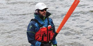 Man holding a paddle wearing paddling gear