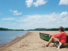 woman takes a break with her dog while canoeing the lower Wisconsin River