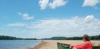 woman takes a break with her dog while canoeing the lower Wisconsin River