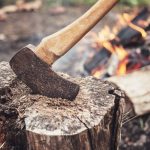 The Axe: Outdated Or Valuable Paddlers Tool? an axe in a log