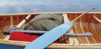 painted paddle sitting across canoe